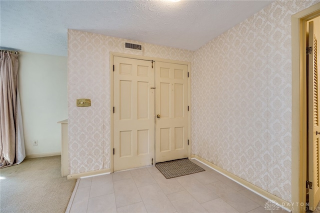 entrance foyer with wallpapered walls and visible vents