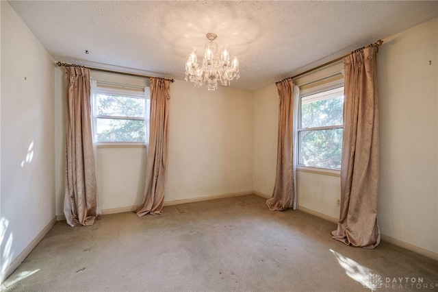 unfurnished room with plenty of natural light, a textured ceiling, and carpet floors