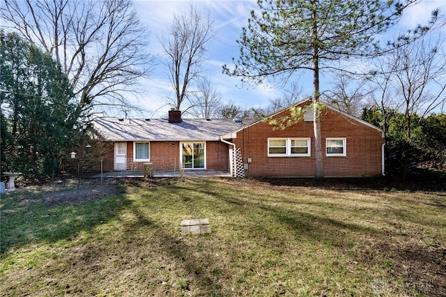 view of front of property featuring a front yard, brick siding, and a chimney