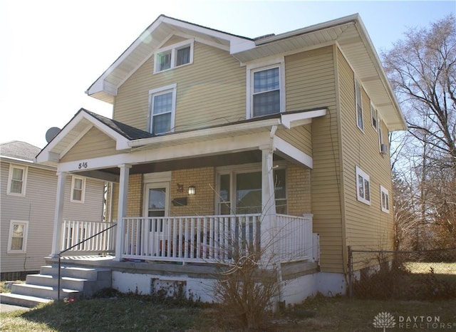 view of front facade featuring covered porch and fence