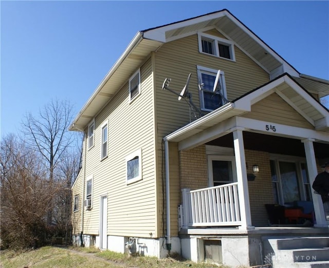 view of home's exterior featuring a porch and cooling unit