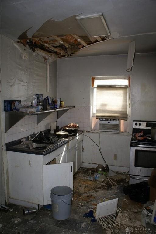 kitchen with electric stove, a sink, white cabinetry, cooling unit, and decorative backsplash