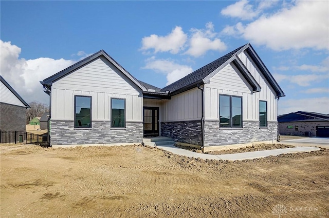 modern inspired farmhouse with stone siding and board and batten siding