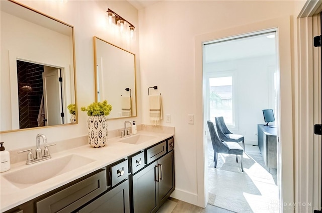 bathroom featuring double vanity, baseboards, and a sink