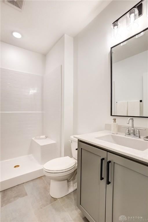 full bathroom with tile patterned flooring, visible vents, a walk in shower, toilet, and vanity