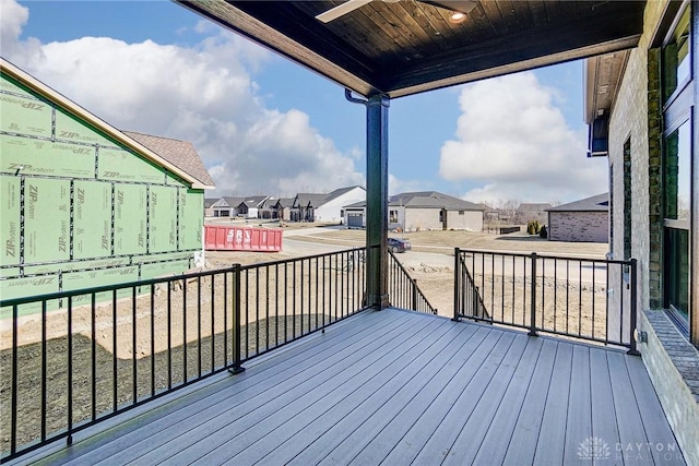 wooden terrace featuring a residential view and a ceiling fan