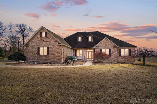 view of front facade featuring brick siding and a front yard