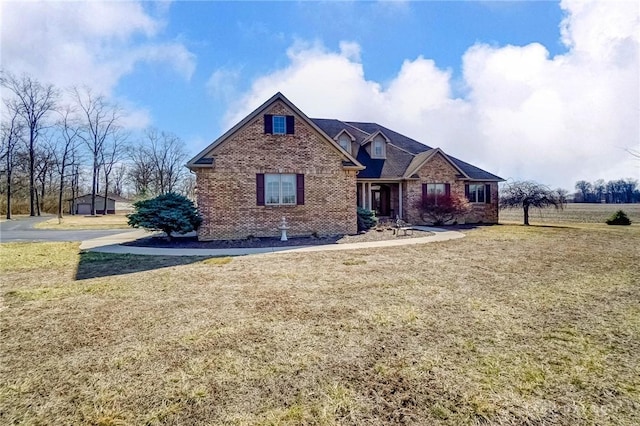 view of front of home with brick siding and a front yard