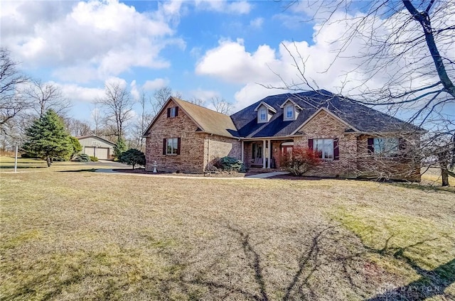 view of front of property featuring brick siding, an outdoor structure, and a front lawn