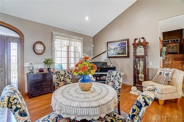 dining space featuring vaulted ceiling, light wood-style flooring, and a wealth of natural light