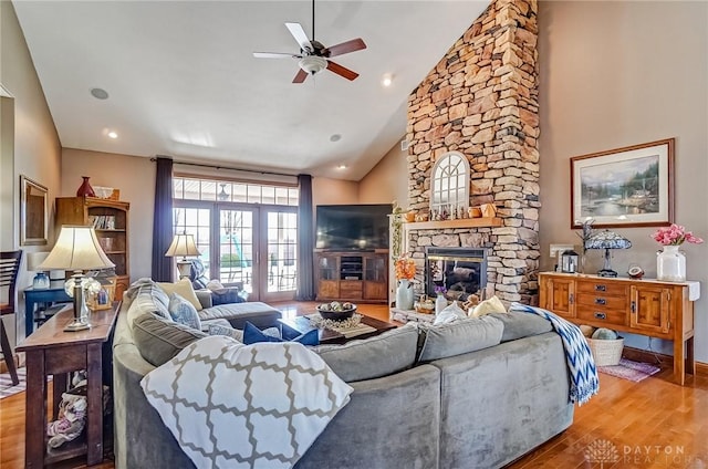 living area with recessed lighting, a fireplace, wood finished floors, high vaulted ceiling, and a ceiling fan