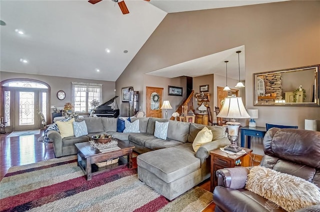 living area featuring high vaulted ceiling, a ceiling fan, wood finished floors, recessed lighting, and stairs