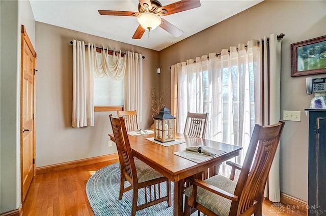 dining area with ceiling fan, baseboards, and wood finished floors