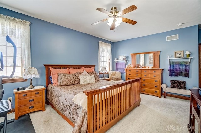 carpeted bedroom featuring visible vents and a ceiling fan