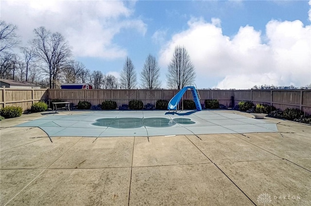 view of pool with a fenced in pool, a patio, a water slide, and a fenced backyard