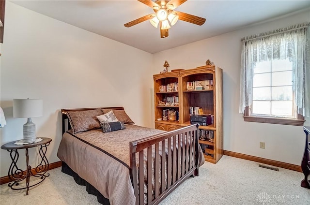 carpeted bedroom with visible vents, baseboards, and a ceiling fan