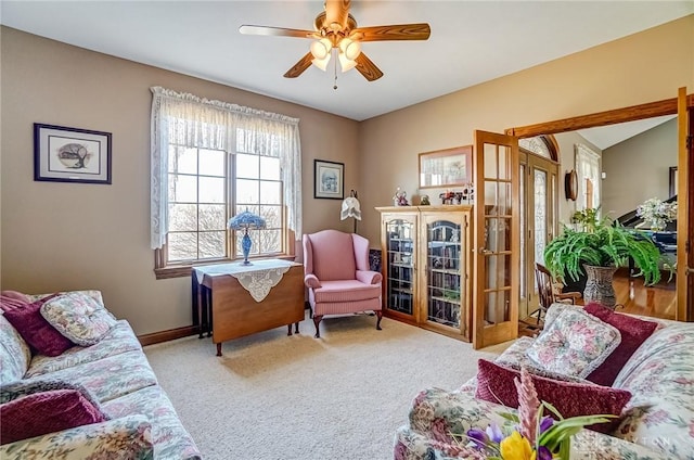 interior space featuring french doors, baseboards, carpet floors, and ceiling fan