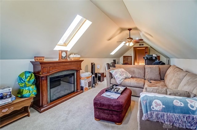 living room with lofted ceiling with skylight, a glass covered fireplace, and carpet floors