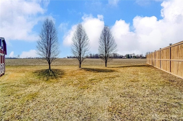 view of yard featuring a rural view and fence