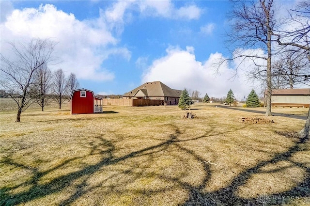 view of yard featuring an outdoor structure, fence, and a barn