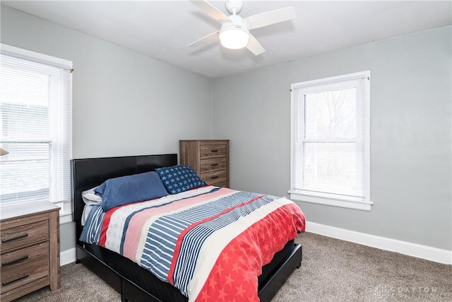 carpeted bedroom with multiple windows, baseboards, and ceiling fan