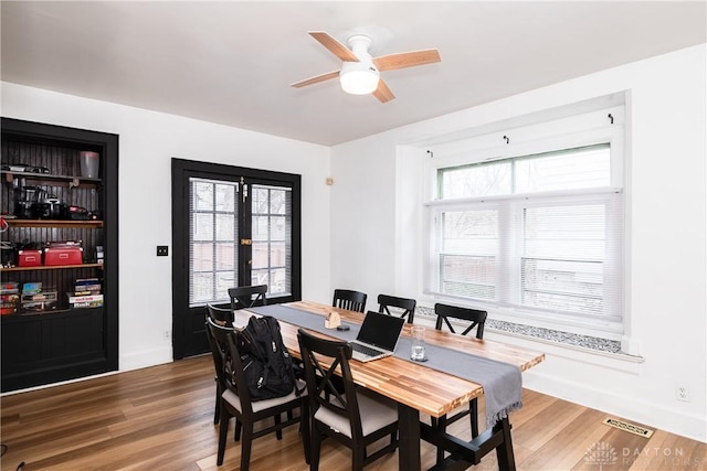 dining area with ceiling fan, wood finished floors, visible vents, and baseboards