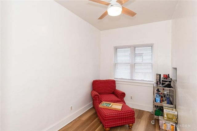 sitting room featuring ceiling fan, baseboards, and wood finished floors