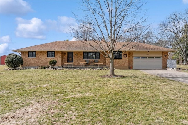 single story home featuring driveway, roof with shingles, a front yard, an attached garage, and brick siding