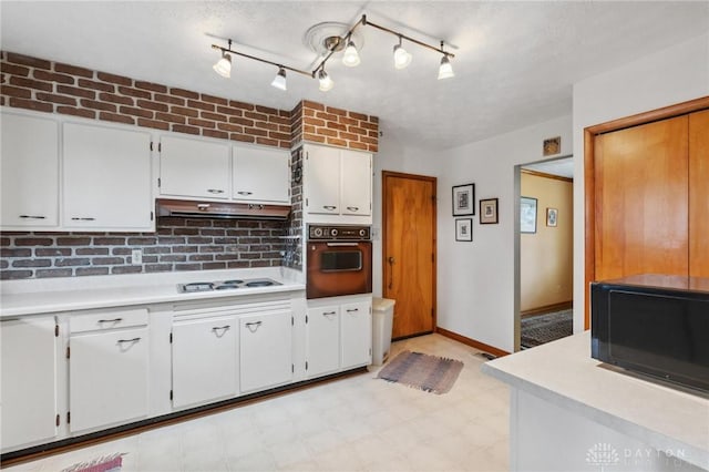 kitchen featuring wall oven, light countertops, black microwave, and white cooktop