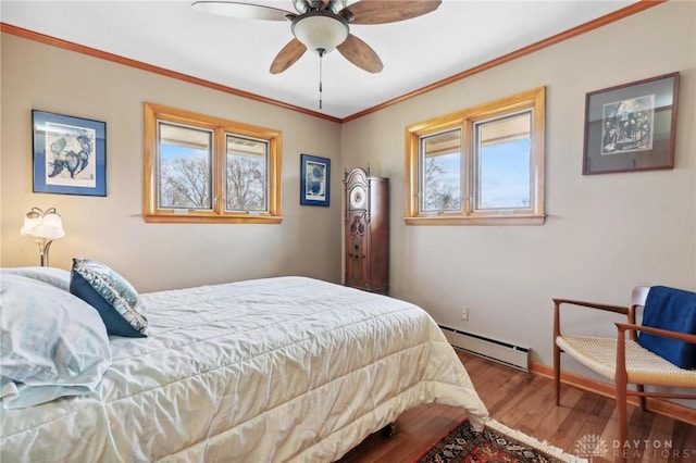 bedroom featuring multiple windows, wood finished floors, crown molding, and a baseboard radiator