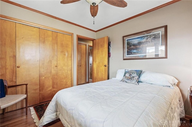 bedroom with ceiling fan, a closet, wood finished floors, and ornamental molding