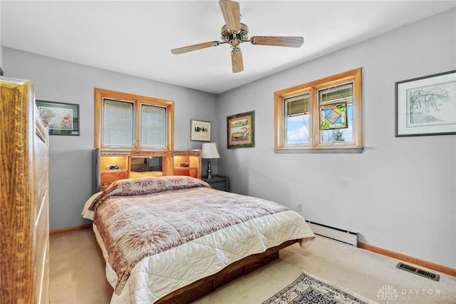 bedroom featuring a ceiling fan, baseboards, visible vents, carpet floors, and a baseboard heating unit