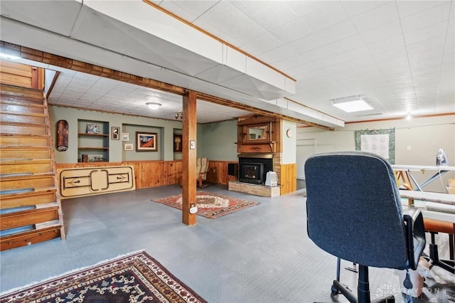 home office with wooden walls, wainscoting, and a fireplace