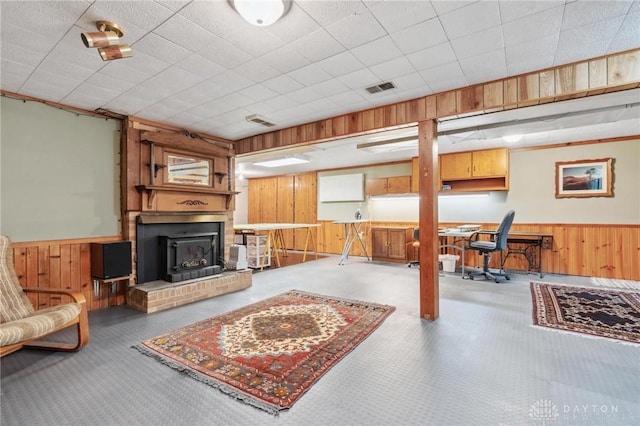 living room with visible vents, wainscoting, and wooden walls