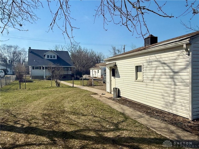 view of home's exterior with a yard and fence