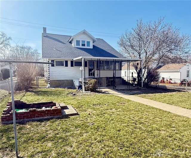 view of front of house featuring fence, a shingled roof, a front lawn, and a patio area