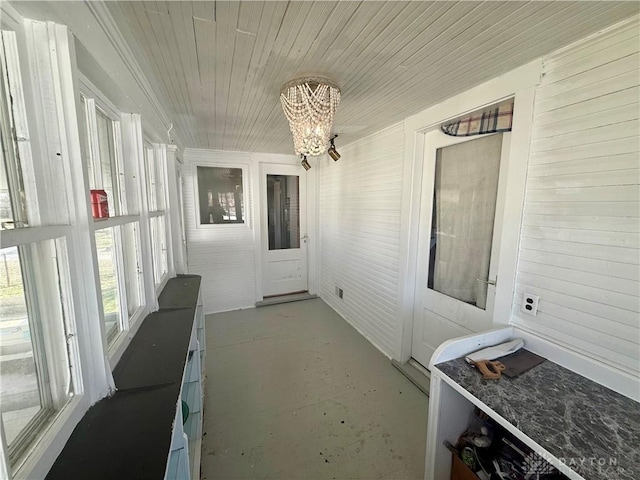 sunroom with a notable chandelier and wood ceiling