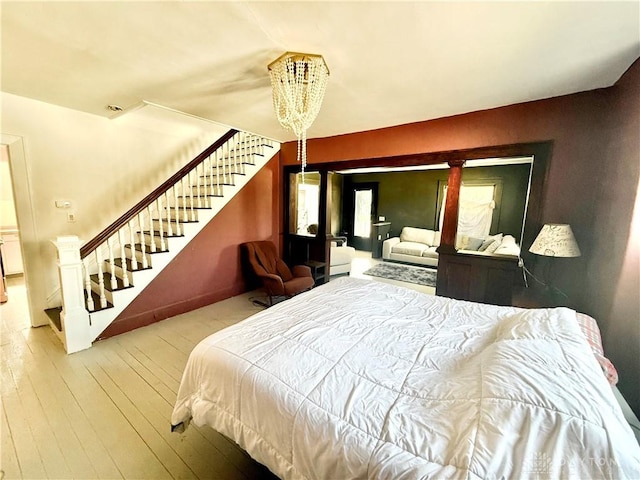 bedroom with an inviting chandelier and wood-type flooring