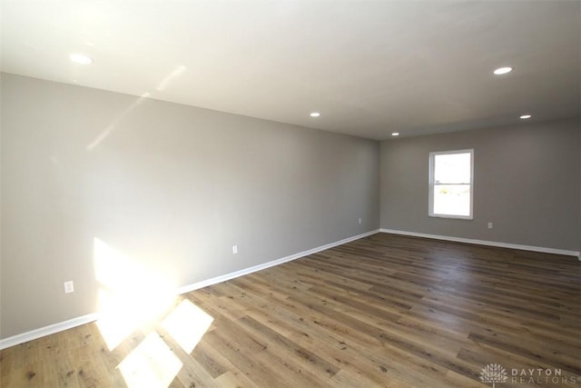 empty room featuring recessed lighting, baseboards, and wood finished floors