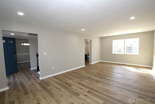 spare room featuring recessed lighting, baseboards, and wood finished floors