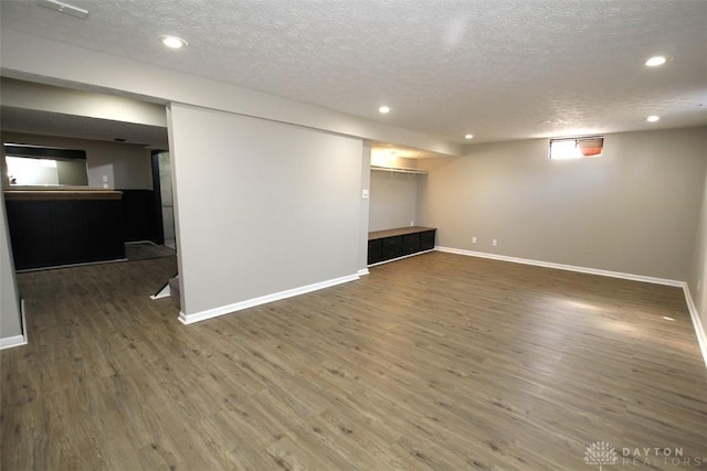 finished below grade area with recessed lighting, baseboards, and wood finished floors