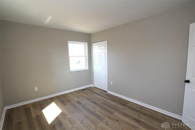 empty room featuring wood finished floors and baseboards