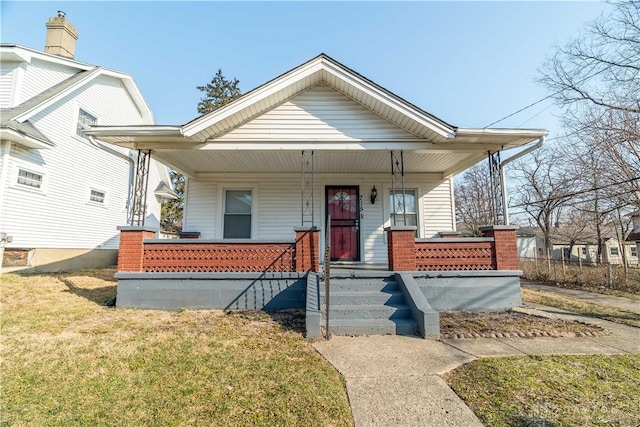 bungalow-style home featuring a porch and a front yard