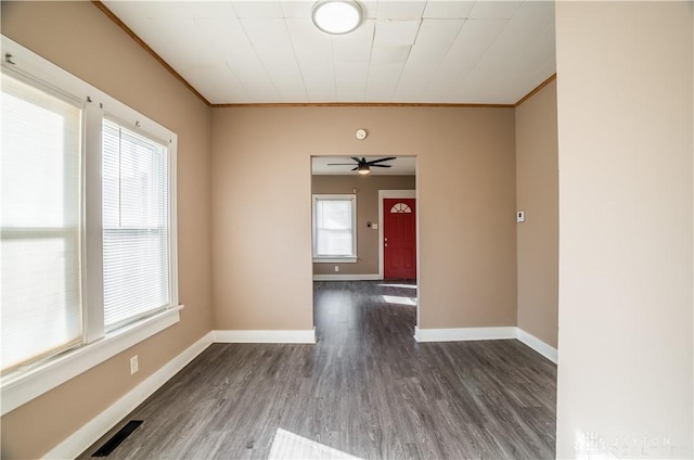 spare room with visible vents, a wealth of natural light, and ornamental molding