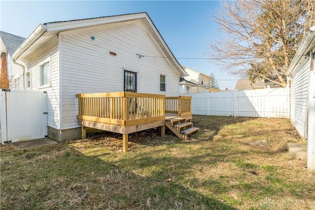 back of property featuring a lawn, a wooden deck, and a fenced backyard