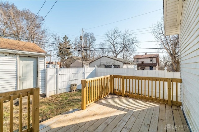 wooden deck with an outbuilding and a fenced backyard