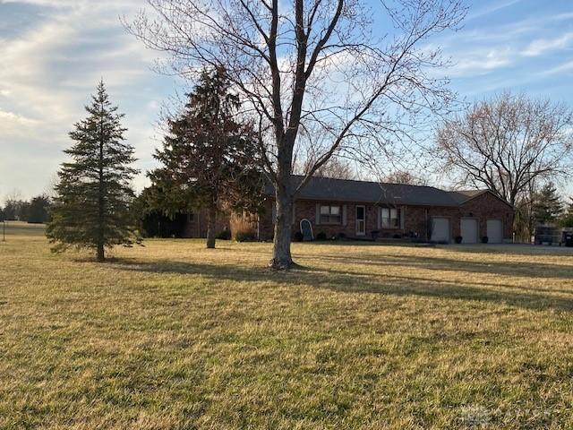 ranch-style home with a garage and a front lawn