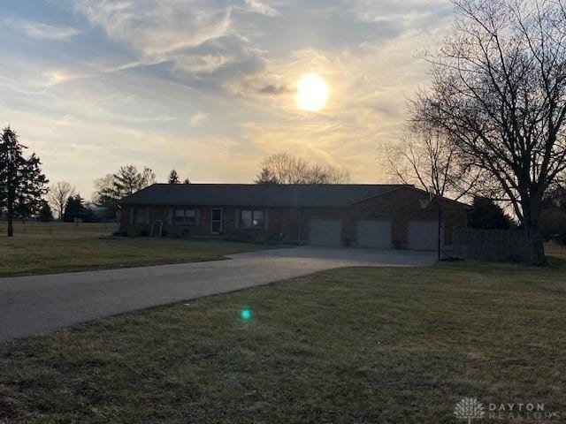 single story home featuring a lawn, an attached garage, and driveway