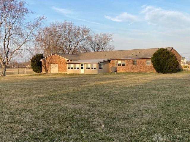 view of front of home with central AC and a front yard