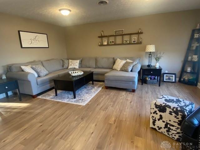 living room with visible vents and light wood-style flooring